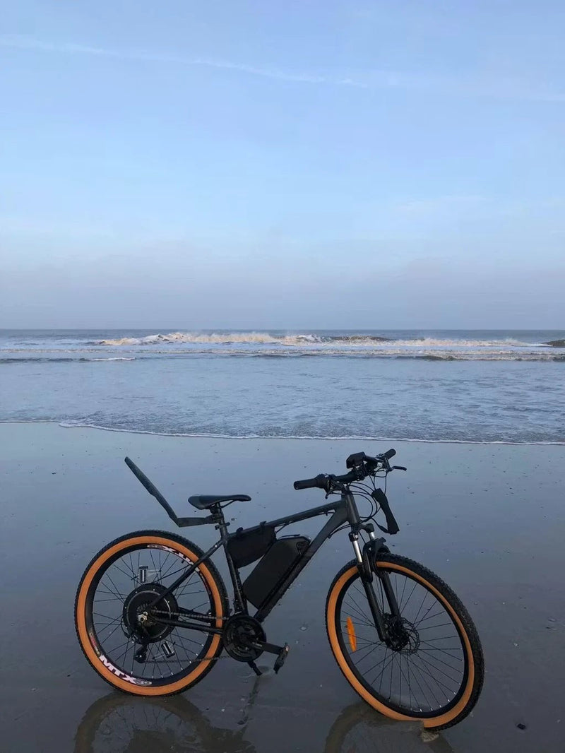 Customer bike converted with a KirbEbike rear hub motor kit and frame battery, parked on a beach